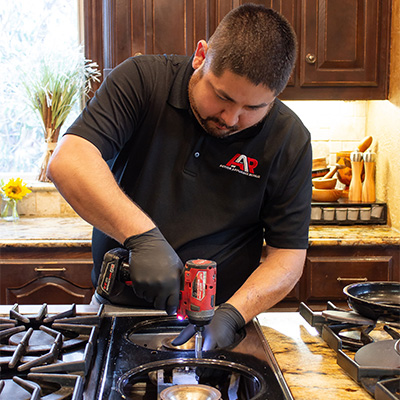 Greg fixing a gas-stove for a happy customer